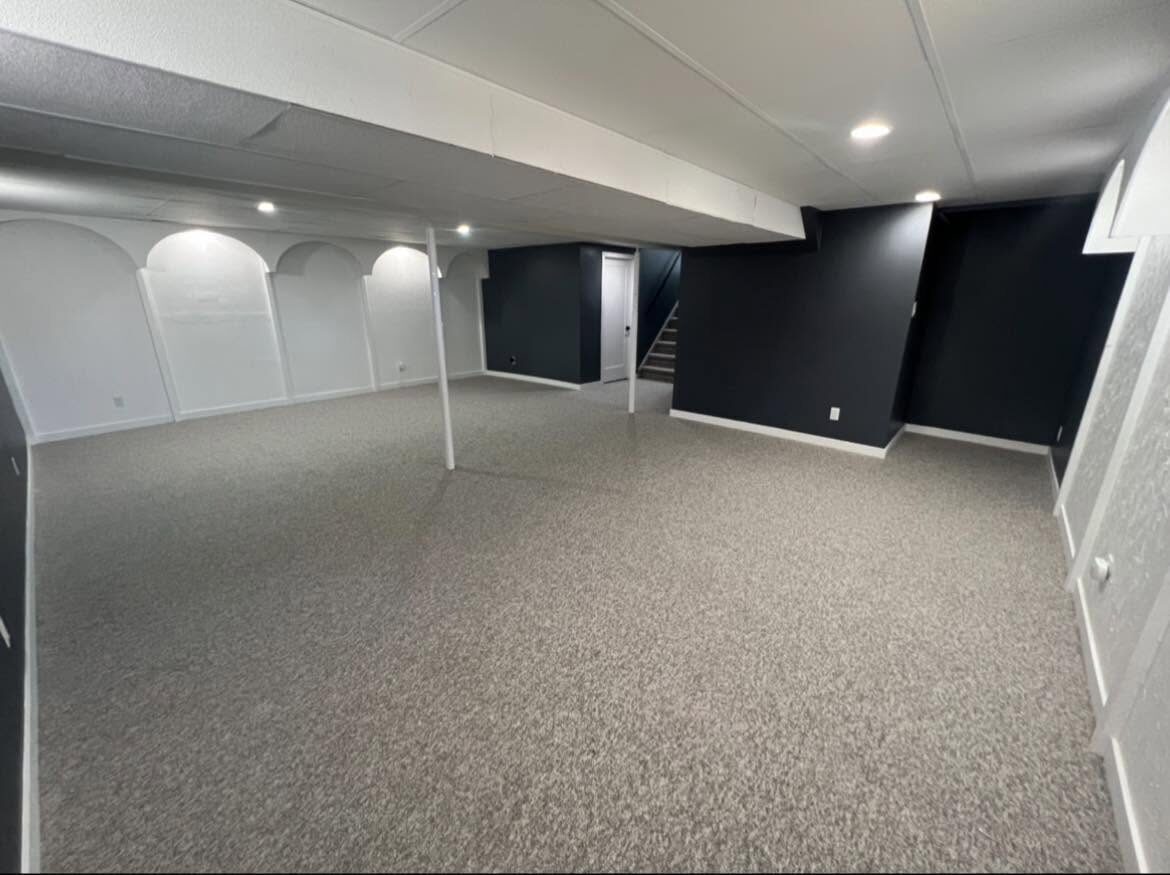 Basement after renovation — carpet, feature wall, arched nooks