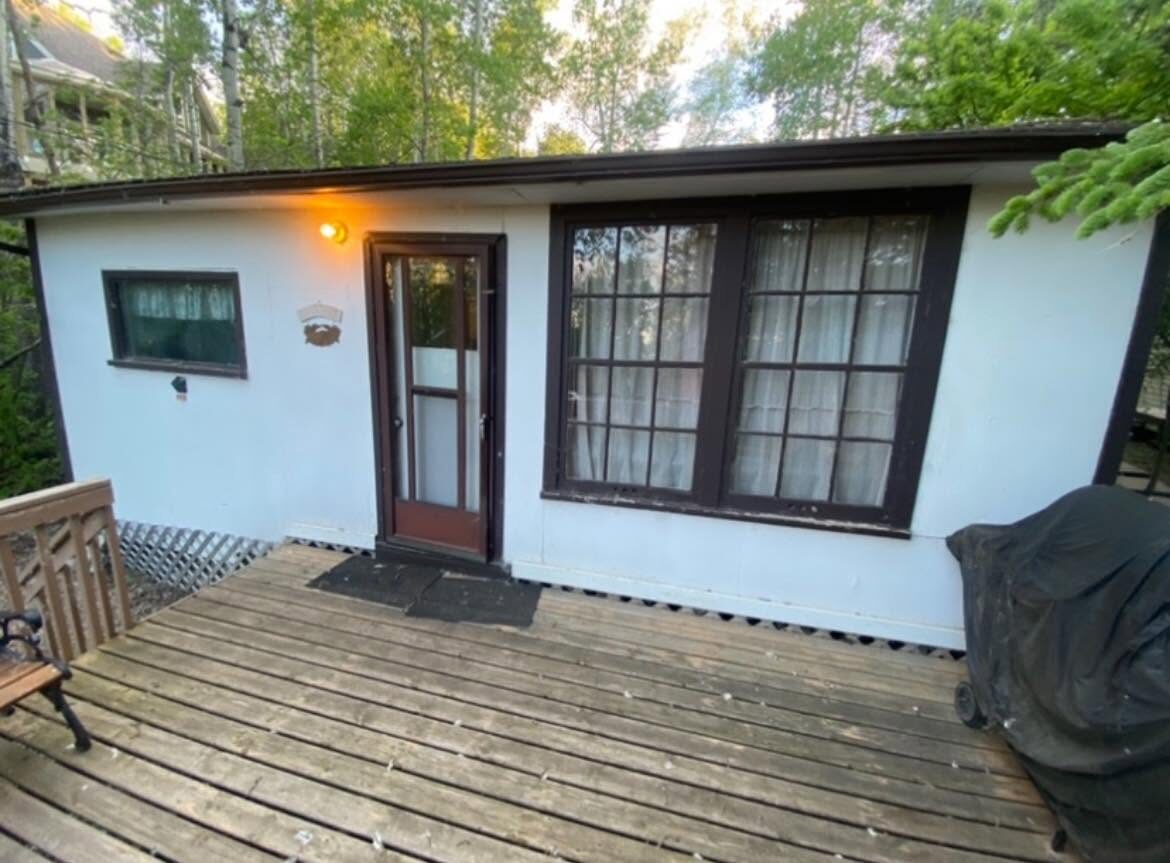 Lake cabin before — weathered paint and old deck