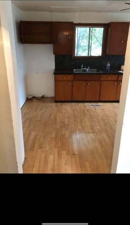 Kitchen before renovation — dated wood cabinets