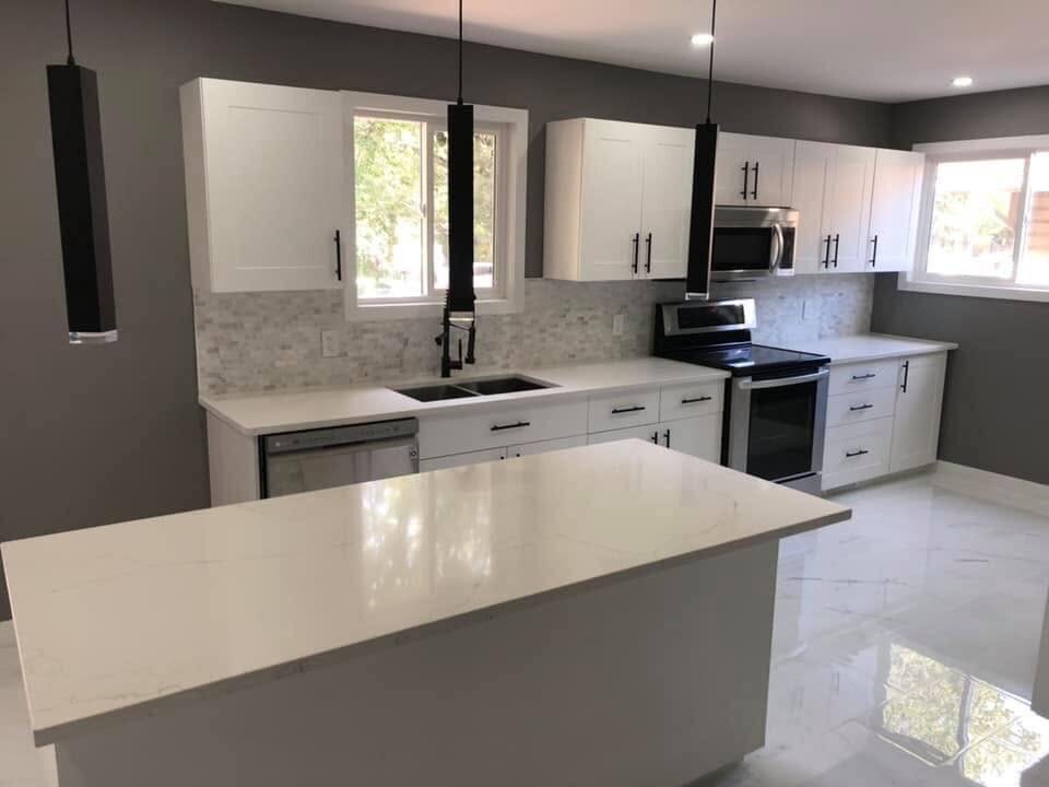 Kitchen after — modern two-tone kitchen with island and pendant lighting