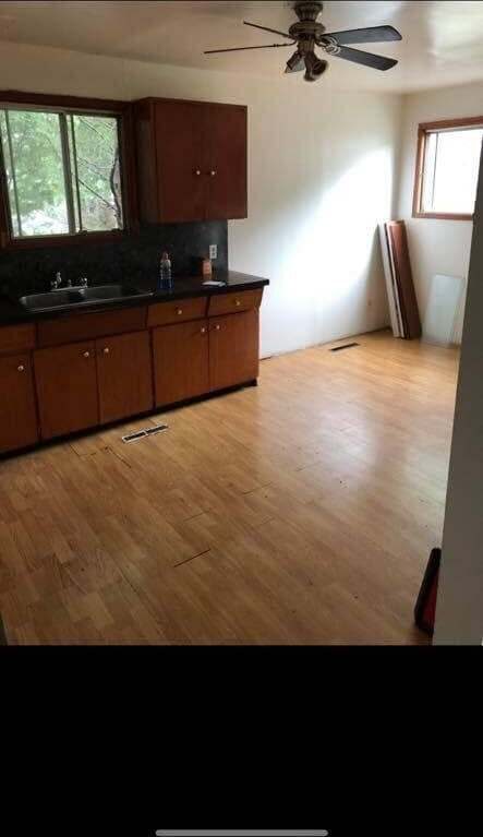 Kitchen before — dark wood cabinets and worn flooring