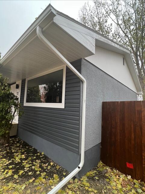 Renovated home exterior with new stucco and siding