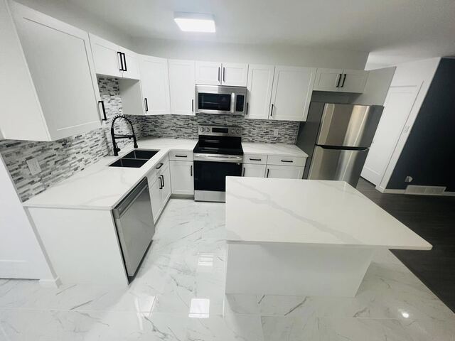 Completed modern white kitchen with quartz island
